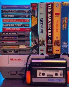 an old school cassette player sitting next to a stack of video games