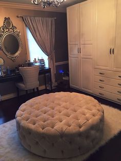 a large round ottoman sitting on top of a rug in front of a white dresser