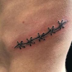 a tattoo on the back of a man's neck that has barbed wire attached to it