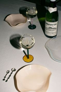 a table topped with wine glasses next to a bottle of wine and a pair of scissors