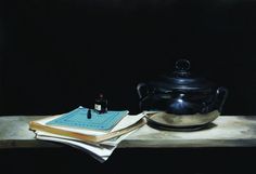 a black pot sitting on top of a table next to a book