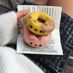 a person holding a doughnut with chocolate sprinkles on it