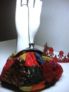 "Vintage SANTI EVENING BAG - Mini-Multicolor Sequins, Beads & Silk Evening Bag, Clutch, Shoulder Bag or Should/Cross-Body Bag. Dar Gray Metallic Frame and Chain Strap. Some minor signs of wear, including some separation of the orange silk threading. Clean red lining. Measures 6\" long, 5\" to top of kiss-lock and 3.5\" deep with a 25\" strap drop. Original \"Santi\" label. Will not hold a cell phone." Handmade Multicolor Handheld Evening Bag, Embellished Multicolor Evening Bag, Multicolor Beaded Handheld Shoulder Bag, Vintage Multicolor Beaded Evening Bag, Multicolor Beaded Pouch Evening Bag, Gift Embellished Multicolor Shoulder Bag, Embellished Multicolor Bags As Fashion Accessory, Multicolor Beaded Pouch Bag, Multicolor Handmade Party Bag