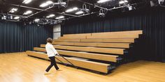 a person with a mop walking in front of some empty seats