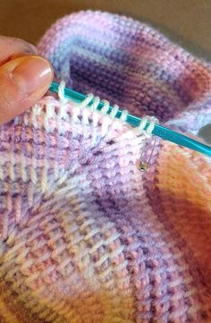 someone is stitching the stitches on a knitted sweater