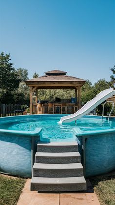 an above ground swimming pool with stairs leading up to the water slide and a gazebo in the background