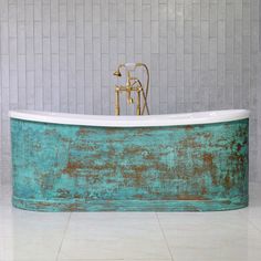 an old bathtub with rusted paint and brass fixtures in a white tiled bathroom