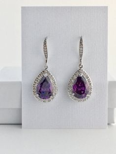 I've created these gorgeous purple amethyst cubic zirconia bridal tear drop dangle earrings in rhodium plated brass setting. Earrings feature a large teardrop with pear cut purple amethyst cubic zirconia center surrounded by tiny round zirconia crystals. Teardrop dangles from a cubic zirconia detailed ear wire. Total length of the earring is 3.8 cms. For matching necklace click: https://www.etsy.com/listing/479272957/amethyst-cubic-zirconia-teardrop-bridal?ref=shop_home_active_19 For matching br Purple Cubic Zirconia Earrings For Pierced Ears, Amethyst Gemstone Earrings For Party, Formal Amethyst Drop Earrings, Purple Teardrop Crystal Earrings For Wedding, Amethyst Earrings For Party, Purple Teardrop Crystal Earrings For Formal Occasions, Purple Crystal Earrings For Wedding, Lavender Crystal Earrings For Wedding, Elegant Lavender Crystal Earrings For Wedding