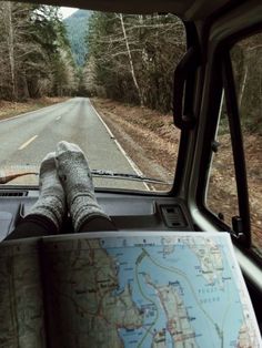 someone's feet on the dashboard of a vehicle with a map in front of them