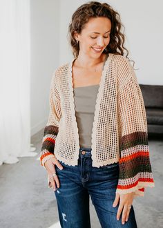 This Leo Crochet Cardigan features a stunning multi-colored sleeve design and a beautiful crochet knit, making it a stylish and versatile piece for any wardrobe. The open front and scalloped detail opening add an elegant touch. Stay warm and fashionable with this must-have cardigan. Trinity is wearing a size small. Fits oversized. Measurements: Body Length: 21.5" | Sleeve Length: 19.5" Small: Bust: 38" Arm: 15" Medium: Bust: 41" Arm: 16" Large: Bust: 44" Arm: 17" 60% Cotton 40% Acrylic Multicolor Knit Crochet Top For Fall, Multicolor Open Knit Outerwear For Spring, Multicolor Open Knit Outerwear For Fall, One Size Long Sleeve Crochet Top For Fall, Bohemian Open Knit Cardigan For Fall, Chic Fall Sweater With Crochet Trim, Trendy Open Knit Crochet Top For Fall, Fall Long Sleeve Crochet Top, Fall Multicolor Crochet Knit Top