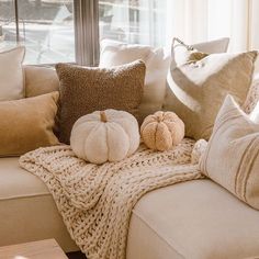 pillows and pumpkins are sitting on a couch