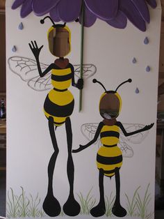 a paper cut out of two bees holding an umbrella