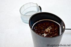 a cup filled with coffee beans sitting on top of a table