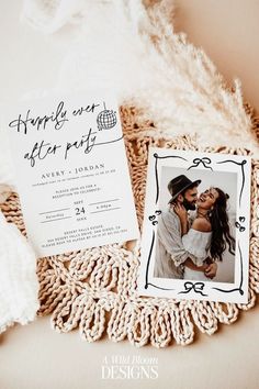 the wedding stationery is laid out on top of an old doily with feathers