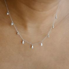 This dainty silver Teardrop Charm Necklace features gold teardrop charms with CZ crystals. This minimalist necklace is perfect for wearing alone or layered up. We make our jewellery in small batches to reduce wastage. Our jewellery is designed with the modern Woman in mind, elegant, unique pieces with a classic touch. Our jewellery is great for gifting, whether it's Valentines, Mothers Day, Birthday or simply a gift for a friend, sister etc. Material- 925 Sterling Silver Chain length- 40+5cm Drop Necklace With Adjustable Chain And Cubic Zirconia, Dainty Cubic Zirconia Drop Necklace, Delicate Teardrop Diamond Necklace, Silver Dainty Drop Charm Necklace, Silver Teardrop Charm Necklace With Delicate Chain, Dainty Drop Necklace With Cubic Zirconia, Everyday Delicate Chain Drop Necklace, Dainty Teardrop Pendant Drop Necklace, Silver Teardrop Charm Necklace In Dainty Style