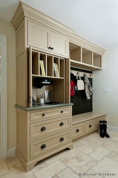 an organized mudroom with cabinets and shoes on the floor