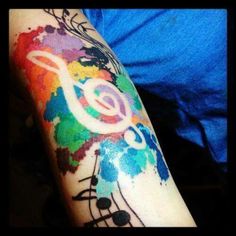 a colorful tattoo with music notes on it