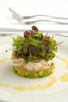 a white plate topped with a salad covered in veggies and garnish