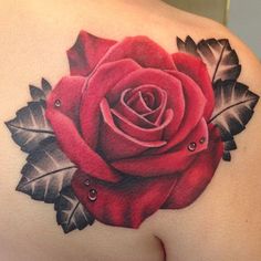 a rose tattoo on the back of a woman's shoulder