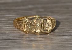 The Humble Vintage Children's 14K Yellow Gold Hand Engraved Ring. Crafted in 14 karat yellow gold, this ring features original hand engraving: DAL. The engraving can be removed and/or re-engraved for an additional charge. Currently a finger size 2.25, this ring can also be resized for an additional charge. Each piece has been hand selected and meticulously identified and graded by a Graduate Gemologist who has been awarded a degree by the Gemological Institute of America (GIA). Please visit our Collectible Yellow Gold Engraved Ring With Hallmarks, Collectible Engraved Yellow Gold Ring With Hallmarks, Gold Engraved Signet Ring Collectible, Hallmarked Yellow Gold Engraved Collectible Ring, Antique Etched Yellow Gold Rings, Antique Stamped Yellow Gold Engraved Ring, Collectible Gold Stamped Ring, Gold Engraved Initial Ring Collectible, Heirloom Engraved Gold Ring With Polished Finish