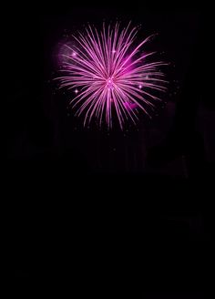 fireworks are lit up in the night sky with bright pink and purple lights on them