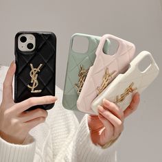 a woman holding three cell phones in one hand and the other is wearing a white sweater