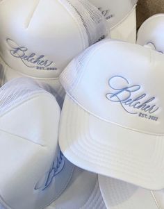 several white hats with embroidered names on them