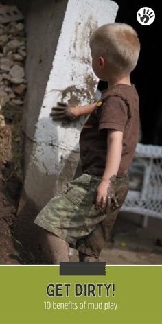 a young boy standing next to a cement block with the words get dirty written on it