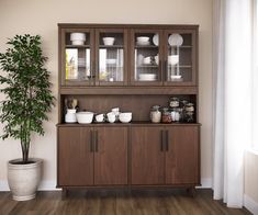 a wooden cabinet with glass doors and dishes on it next to a potted plant