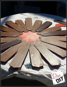 a table with wooden boards arranged in the shape of a flower