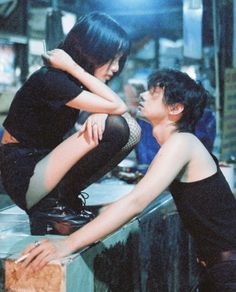 two people sitting on top of a wooden box