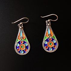 Handmade Sterling Silver Amazigh Earrings with Colorful Enamel Circle Accents These exquisite earrings are a beautiful representation of Amazigh (Berber) artistry from Morocco. Handcrafted with precision, they are made from high-quality sterling silver and adorned with vibrant enamel accents. Design: The design features a water drop shape, which symbolizes water, life, and renewal in Amazigh (Berber) culture.  Materials:  High-quality sterling silver with colorful enamel accents in blue, red, gr Bohemian Multicolor Enamel Earrings, Traditional Multicolor Sterling Silver Earrings, Traditional Colorful Festival Earrings, Multicolor Enamel Teardrop Jewelry, Multicolor Teardrop Enamel Jewelry, Traditional Multicolor Nickel-free Jewelry, Colorful Traditional Earrings, Bohemian Colorful Earrings For Gift, Multicolor Enamel Jewelry