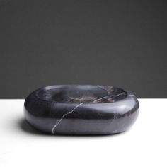 a black marble bowl sitting on top of a white table