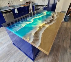 a kitchen island with an ocean scene painted on the countertop and under it is a stainless steel sink