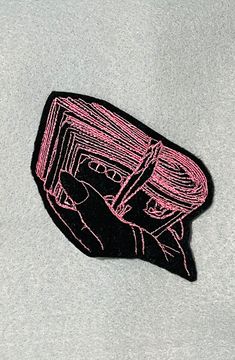 a pink sticker that is on the side of a gray shirt with a hand holding a knife