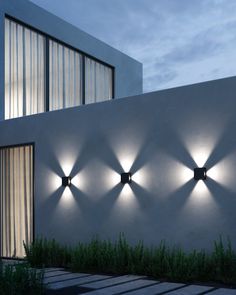 four lights on the side of a white building