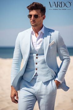 a man in a blue suit standing on the beach