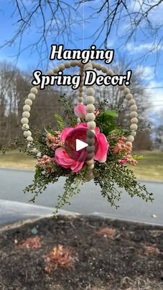 a hanging decoration with flowers and beads on the side of the road that says hanging spring decor