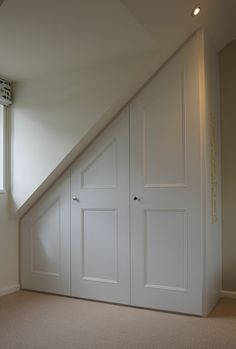 an attic bedroom with two white doors