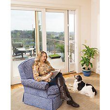 a woman sitting in a blue chair next to a black and white dog