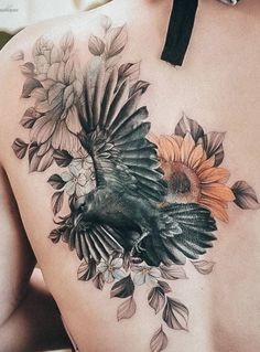 a woman's back with a bird and flowers on it