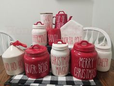 red and white kitchen canisters with merry christmas written on them sitting on a table