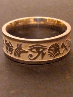 You are buying the Egyptian inspired ring pictured, it features a wonderful stainless  steel band with Egyptian symbols etched all the way around. This wonderful ancient Egyptian pattern inspired Ring will look amazing, very classic look, a great silver-tone accessory for that Egyptian look. Available in size 9  , these lovely rings are new old stock I got them from a costume jewelry warehouse that went out of business in the late 1990s. Please Note: These are comfort fit rings (rounded on the i Ancient Egyptian Jewelry Rings, Ancient Egyptian Accessories, Symbolic Silver Jewelry With Laser Engraving, Symbolic Silver Laser Engraved Jewelry, Symbolic Laser Engraved Silver Jewelry, Symbolic Engraved Ring For Promise, Symbolic Stainless Steel Engraved Ring As Gift, Symbolic Stainless Steel Engraved Ring For Gift, Symbolic Nickel-free Engraved Ring