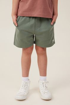 These Henry Slouch Shorts are a summer wardrobe staple. With an elastic waist and drawcord, these shorts are so easy to take on and off yourself - allowing you to spend more time running around and less time changing! Wear with a short sleeve tee and snea

Features:  

 -  Relaxed Fit With Room To Move 
 -  Mid- Thigh Length 
 -  Elastic Waist 
 -  Functional Drawcord 
 -  Side Pocket 
 -  Fun Prints Unique To Cotton On 
 -  Quirky & Fun In-House Designed Placement Prints 
 -  Bold Solid Colours Trendy Green Relaxed Fit Shorts, Green Relaxed Fit Comfortable Shorts, Sporty Green Cotton Shorts, Green Cotton Drawstring Shorts, Green Cotton Playtime Shorts, Green Core, Summer Wardrobe Staples, Fleece Leggings, Knitwear Dress