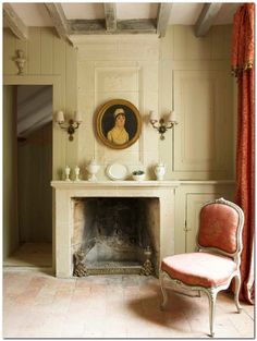 a room with a fireplace, chair and painting on the wall