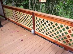 a wooden deck with an iron fence on it and trees in the backround