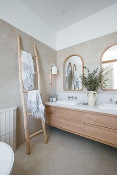 a bathroom with two sinks and a ladder in it