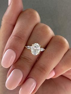 a woman's hand with a ring on it and a diamond in the middle