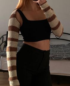 a woman taking a selfie with her cell phone and wearing a knitted arm warmer