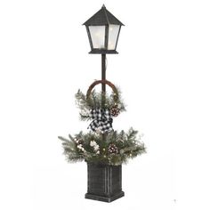 a lamp post with a wreath and pine cones on it